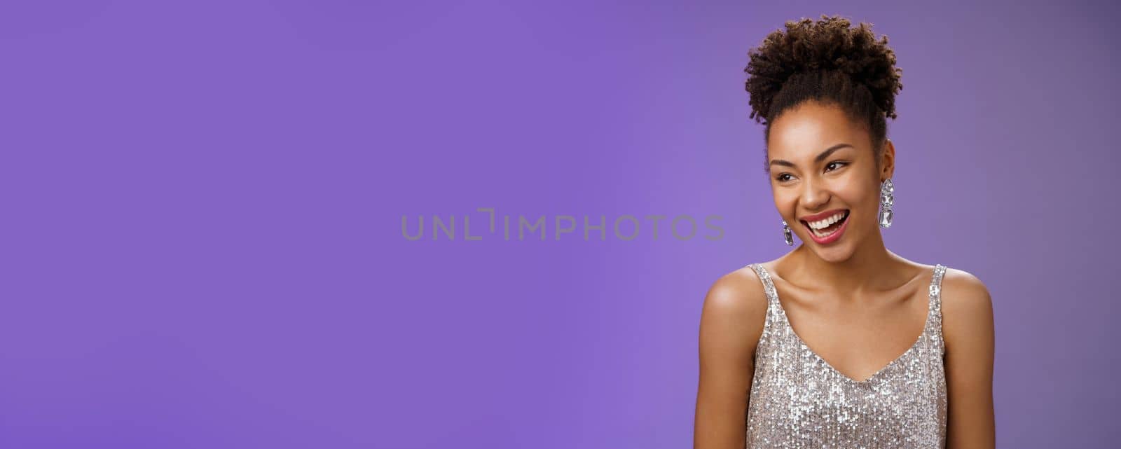 Close-up talkative elegant glamour african-american young girl host party wearing luxurious fashionable silver dress talking laughing happily during conversation standing blue background by Benzoix