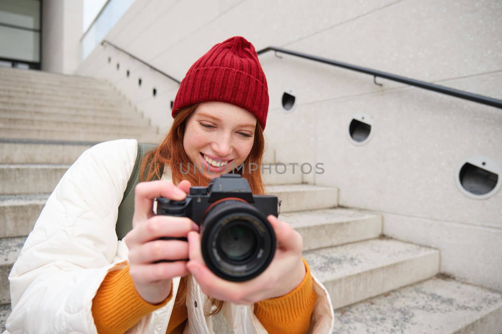 Urban people and lifestyle. Happy redhead woman takes photos, holding professional digital camera, photographing on streets by Benzoix