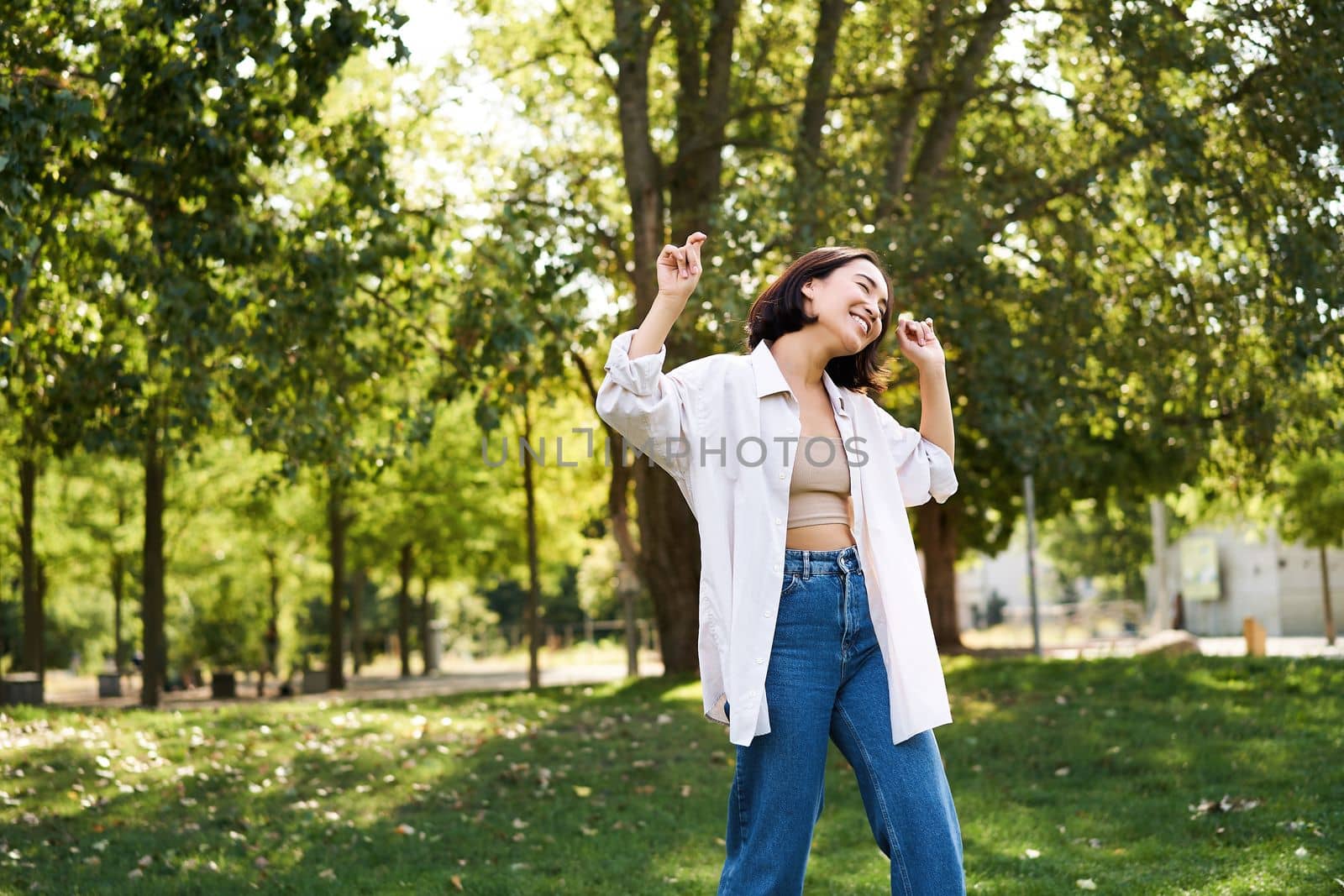 Portrait of happy girl dancing and looking happy, posing in park, enjoying herself, walking alone, feeling freedom and excitement by Benzoix