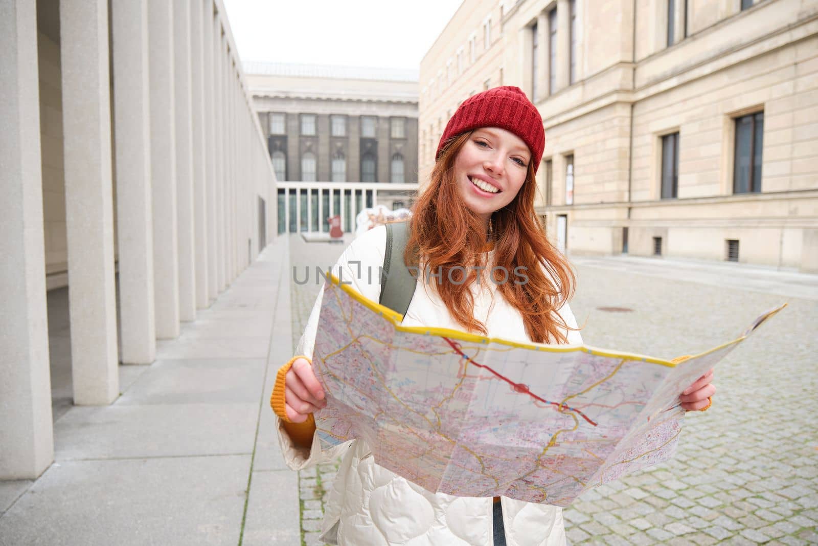 Redhead girl, tourist explores city, looks at paper map to find way for historical landmarks, woman on her trip around euope searches for sightseeing.