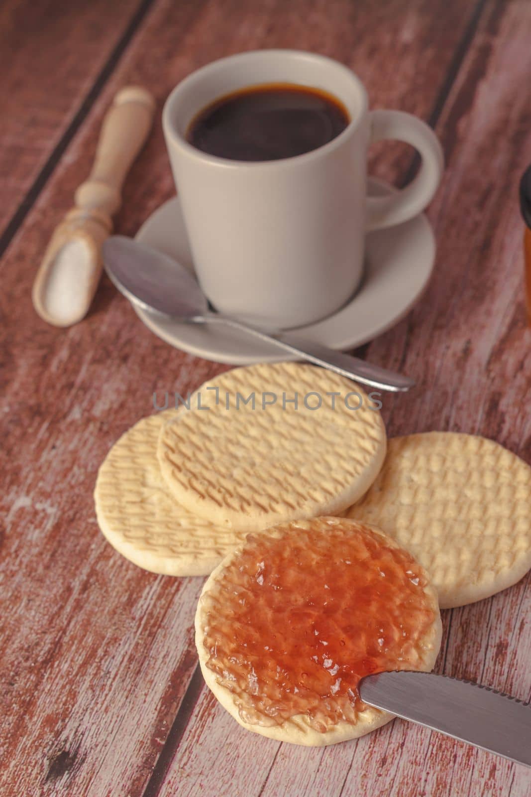cookies with jam and coffee cup on a wooden table