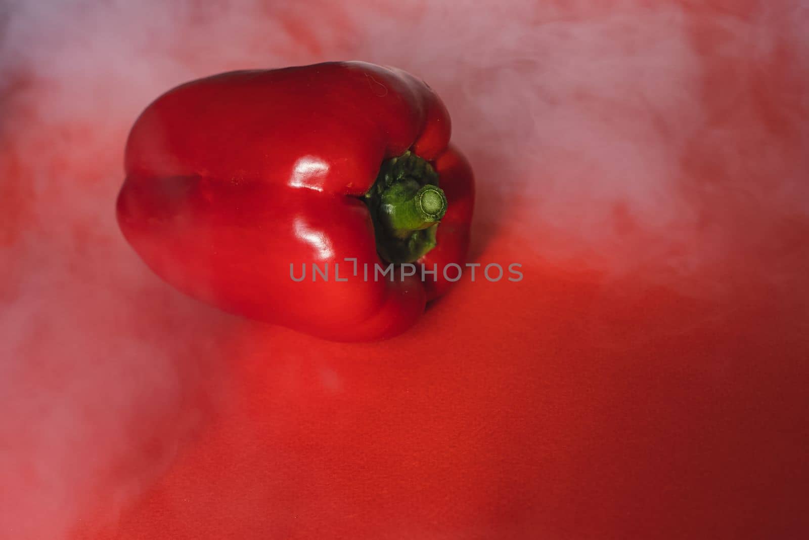 SWEET, fresh RED PEPPER ON RED BACKGROUND With smoke around, pepper. photo for the menu, proper nutrition. fresh vegetables.