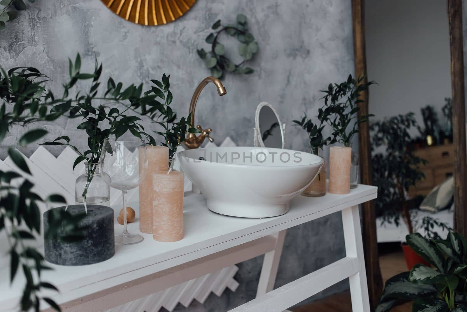 Interior of bathroom with mirror on a white bricky wall, stylish furniture, trendy wash basin and green plants. Houseplant and sp at home. Panoramic