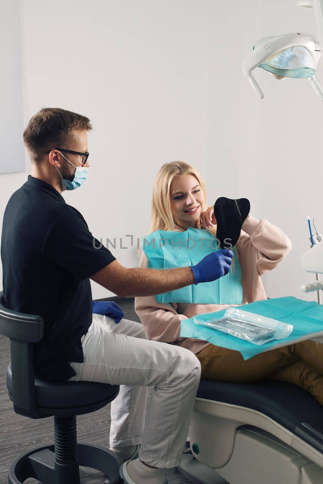 Portrait of a dentist who treats teeth of young woman patient. by Ashtray25