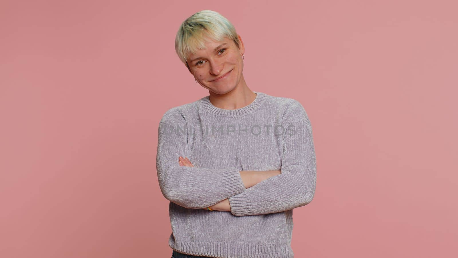 Happy calm young woman with short hair. Girl smiling friendly, glad expression looking away dreaming resting, relaxation feel satisfied concept good news. Pink background. Lgbt gay lesbian people