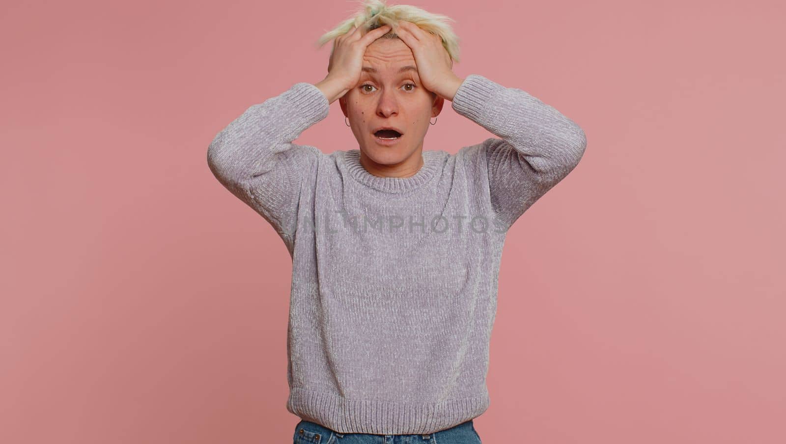 Stressed depressed woman terrified about danger problems, suffering phobia, anxiety disorder, expresses fear, waving no, insecure, stress, panic. Young girl on pink background. Lgbt gay lesbian people
