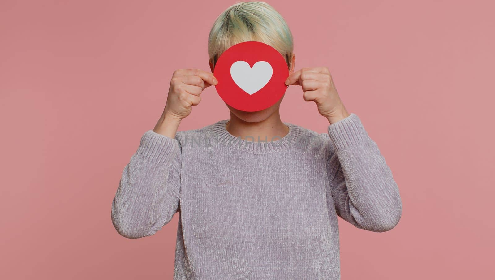 Like. Woman with short hair show heart banner inscription agrees with something, gives positive reply recommends advertisement likes good. Girl on pink studio background. Lgbt gay lesbian people