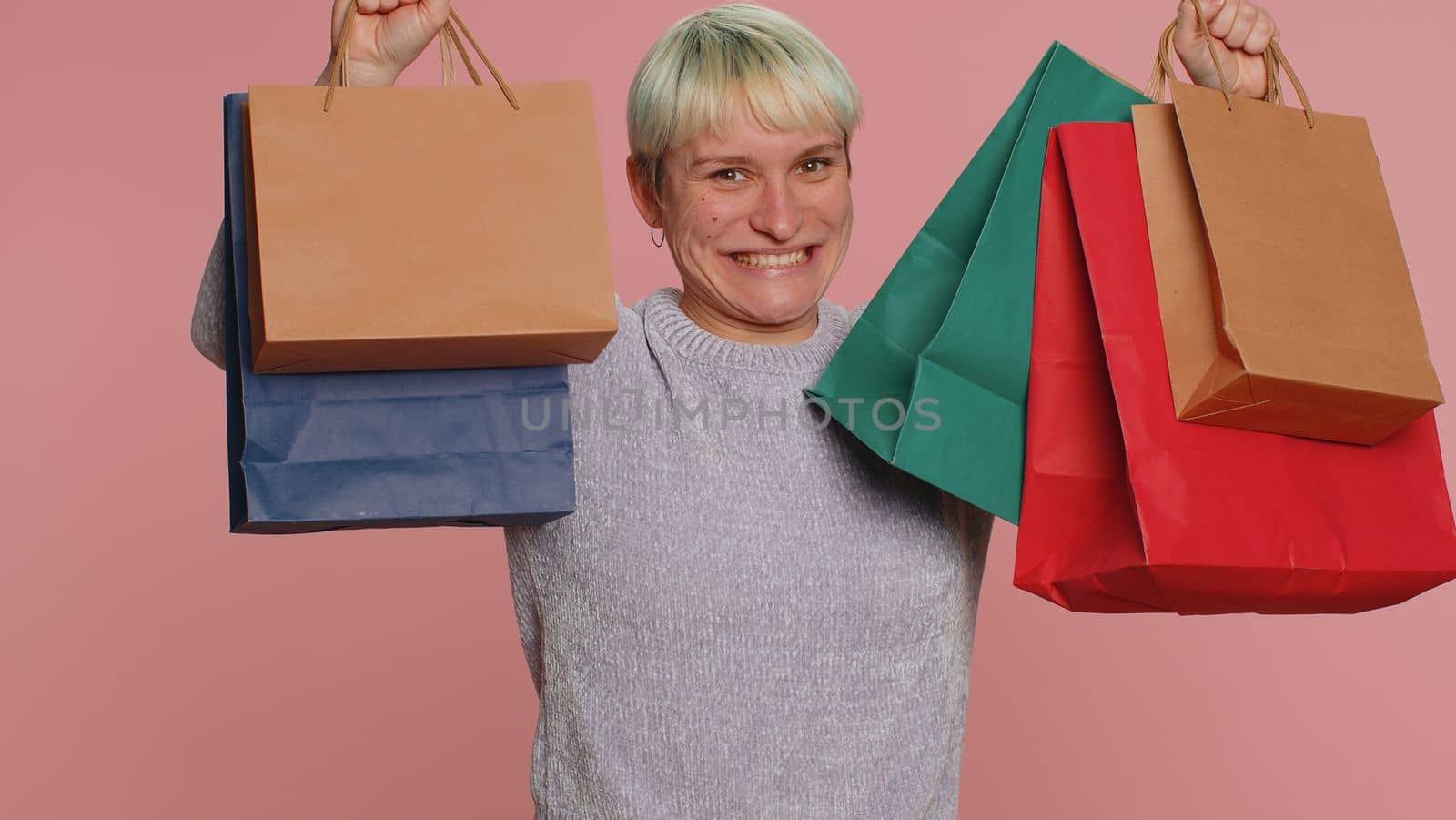 Happy tourist woman showing shopping bags, advertising holidays discounts, amazed with low prices by efuror