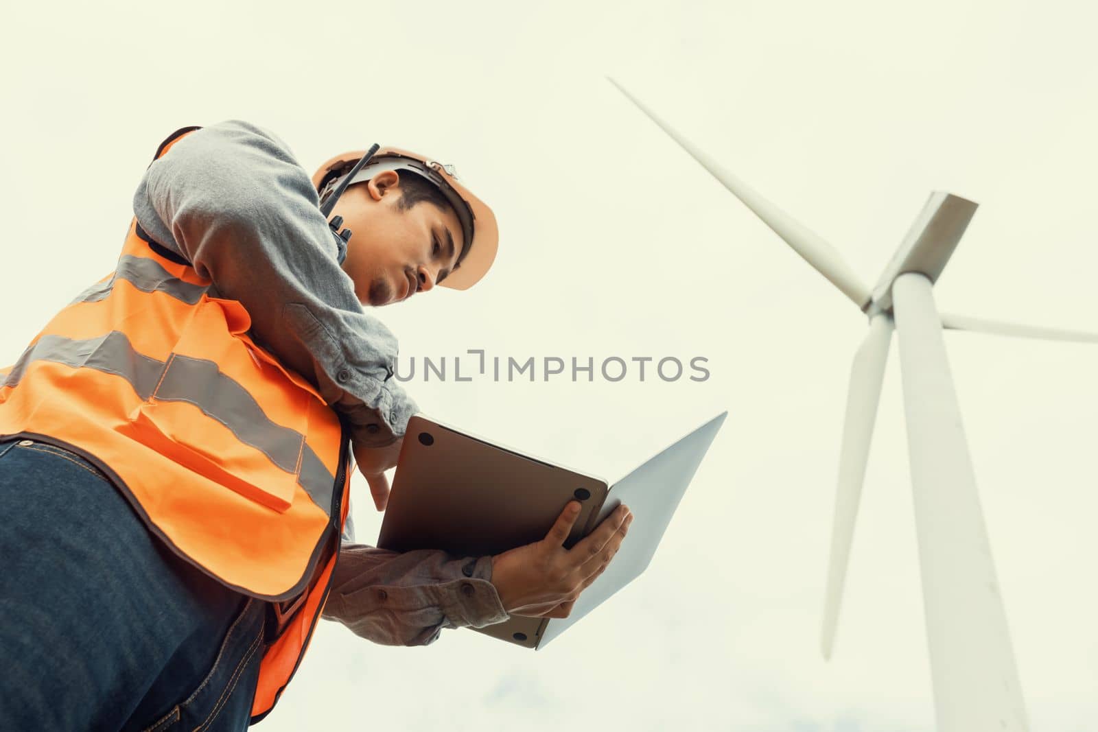 Engineer working on a wind farm atop a hill or mountain in the rural. Progressive ideal for the future production of renewable, sustainable energy. Energy generation from wind turbine.