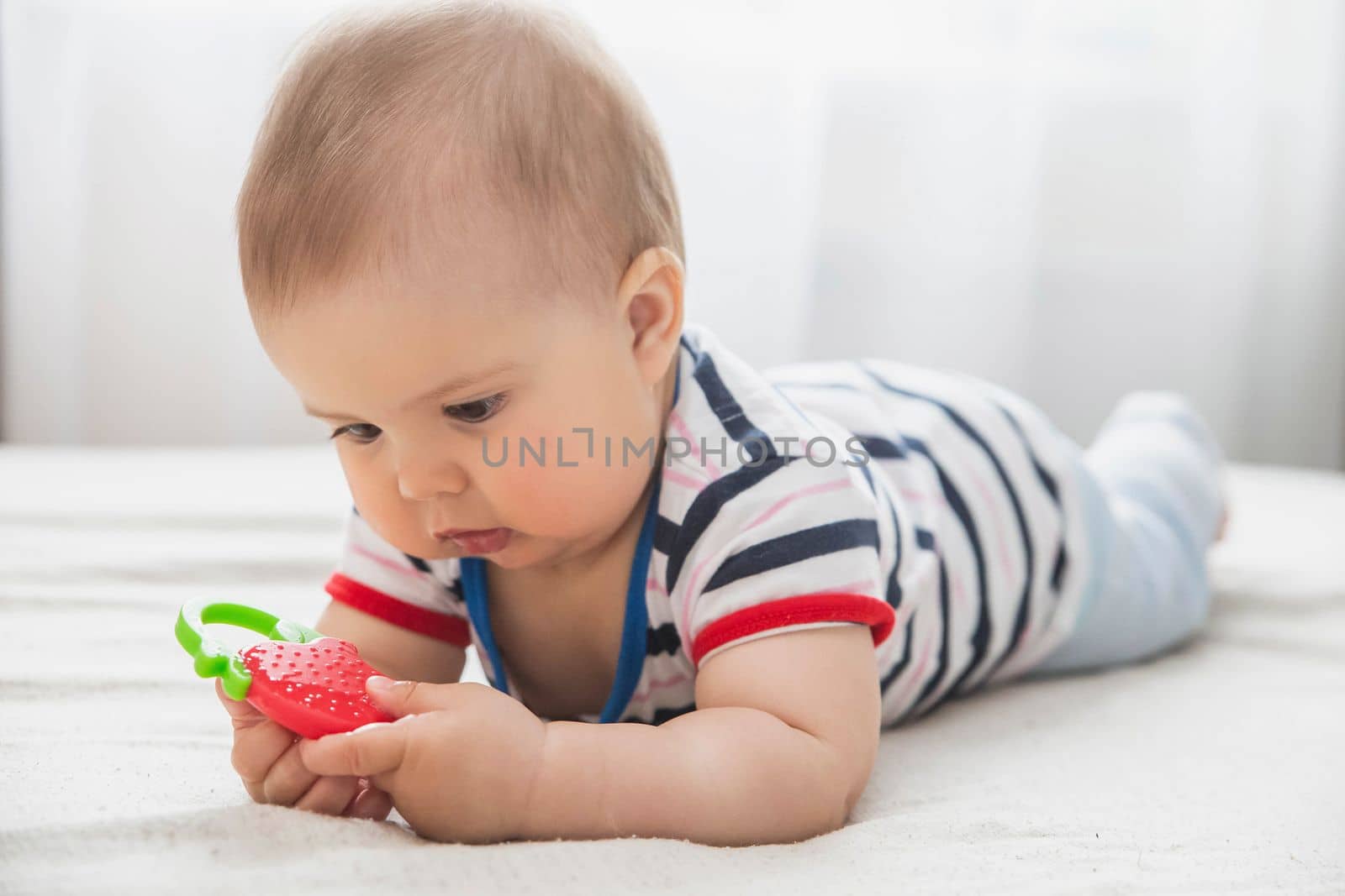 baby is nibble a rubber toy because the teeth are being cut.