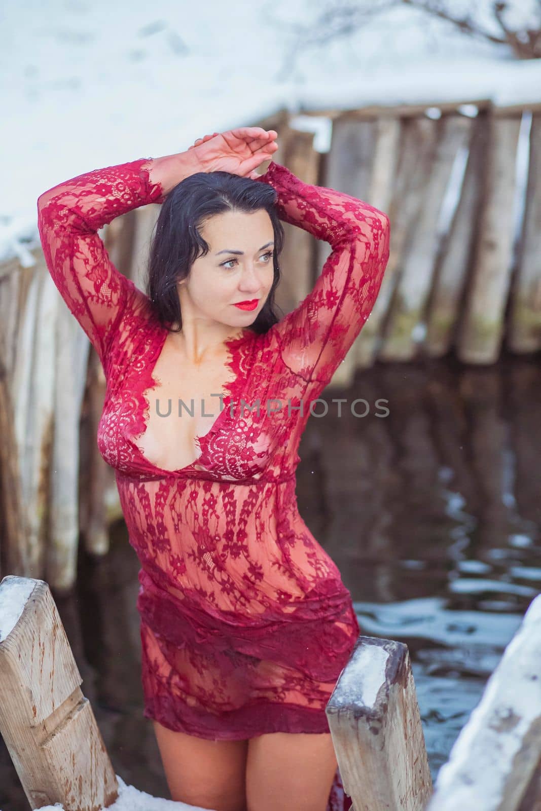 Attractive woman bathes in icy water in a font.