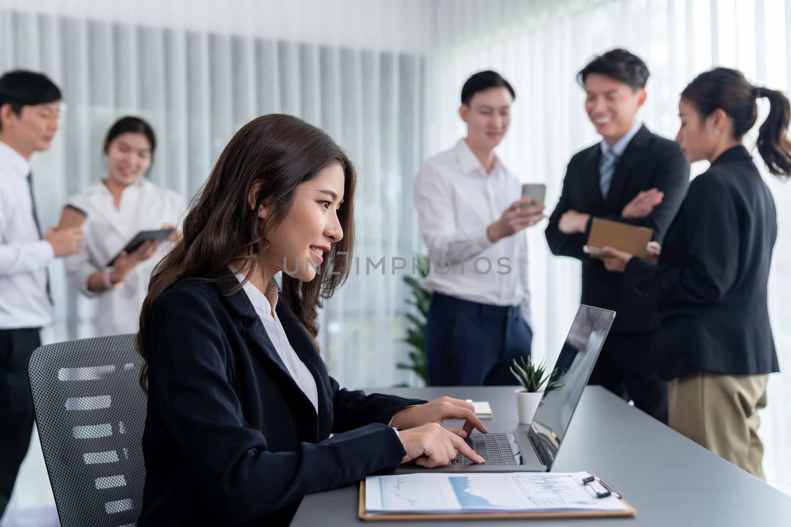 Focus portrait of female manger, businesswoman in the harmony meeting room with blurred of colleagues working together, analyzing financial paper report and dashboard data in background.