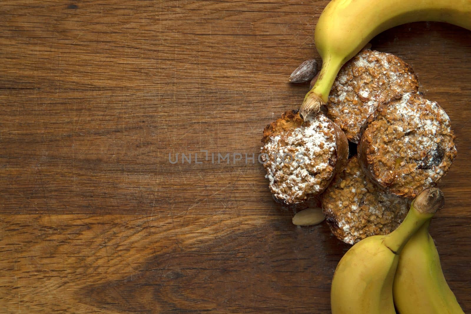 Freshly baked banana muffins top view on wooden background with copy space, healthy vegan cupcakes, diet vegetarian concept by Annebel146