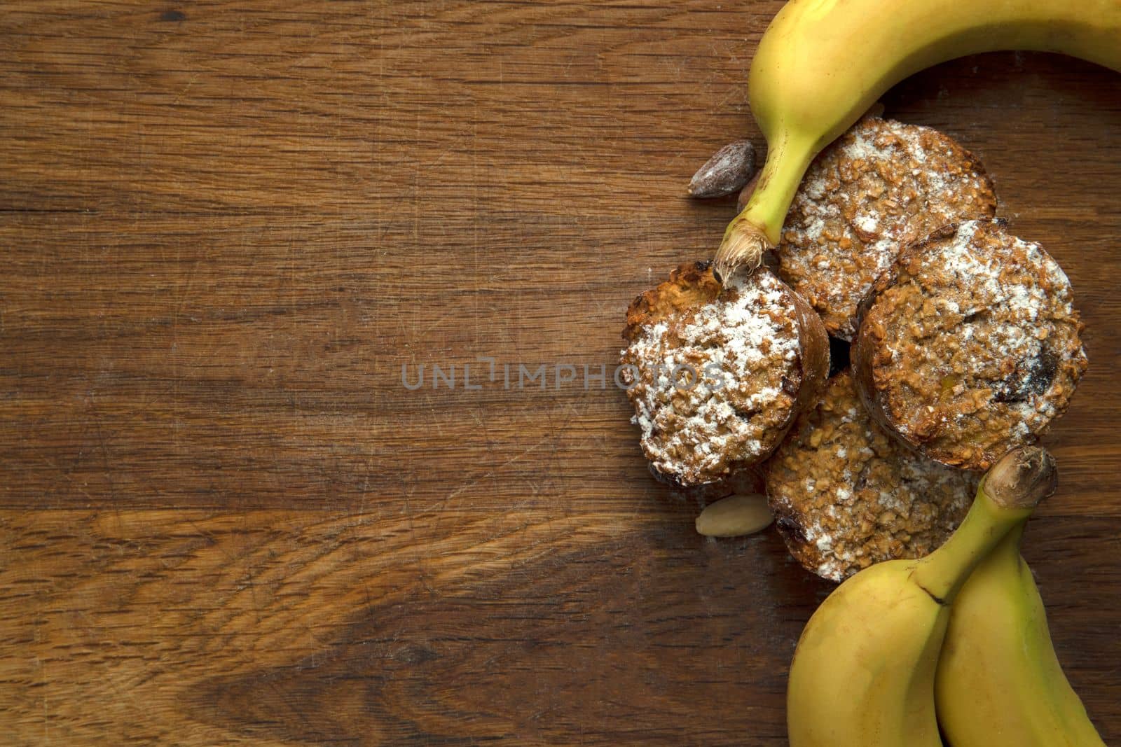 Freshly baked banana muffins top view on wooden background with copy space, healthy vegan cupcakes, diet vegetarian concept top view