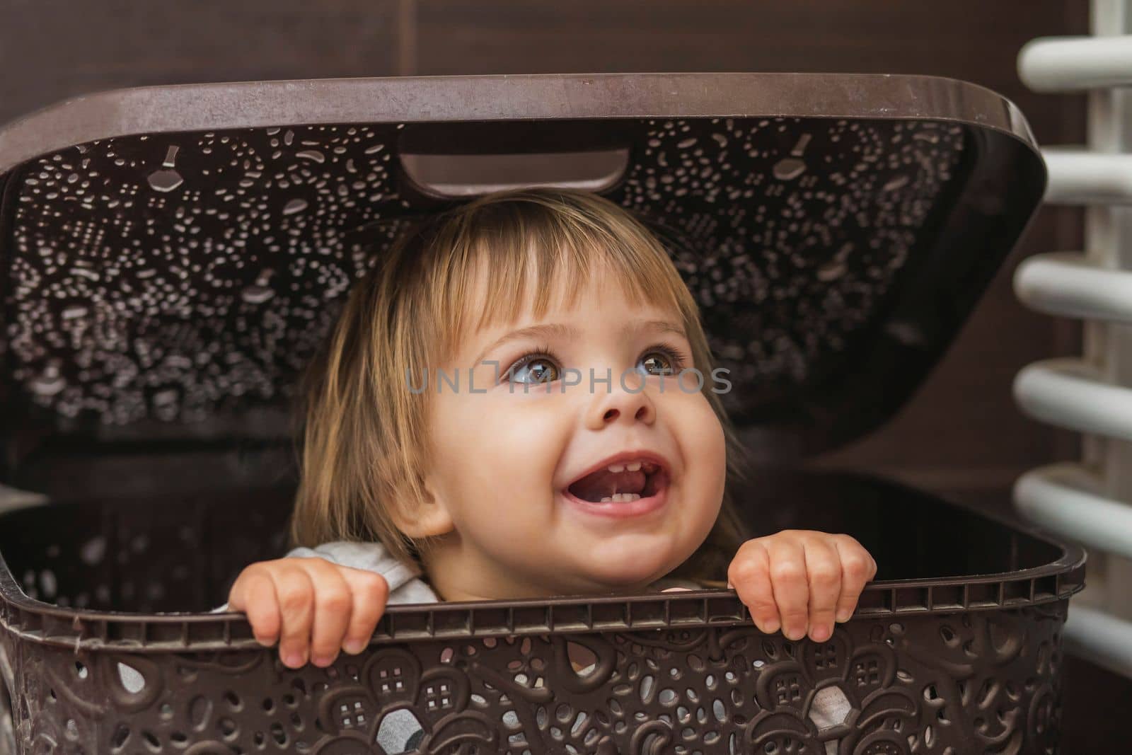 adorable baby hiding in a laundry basket.