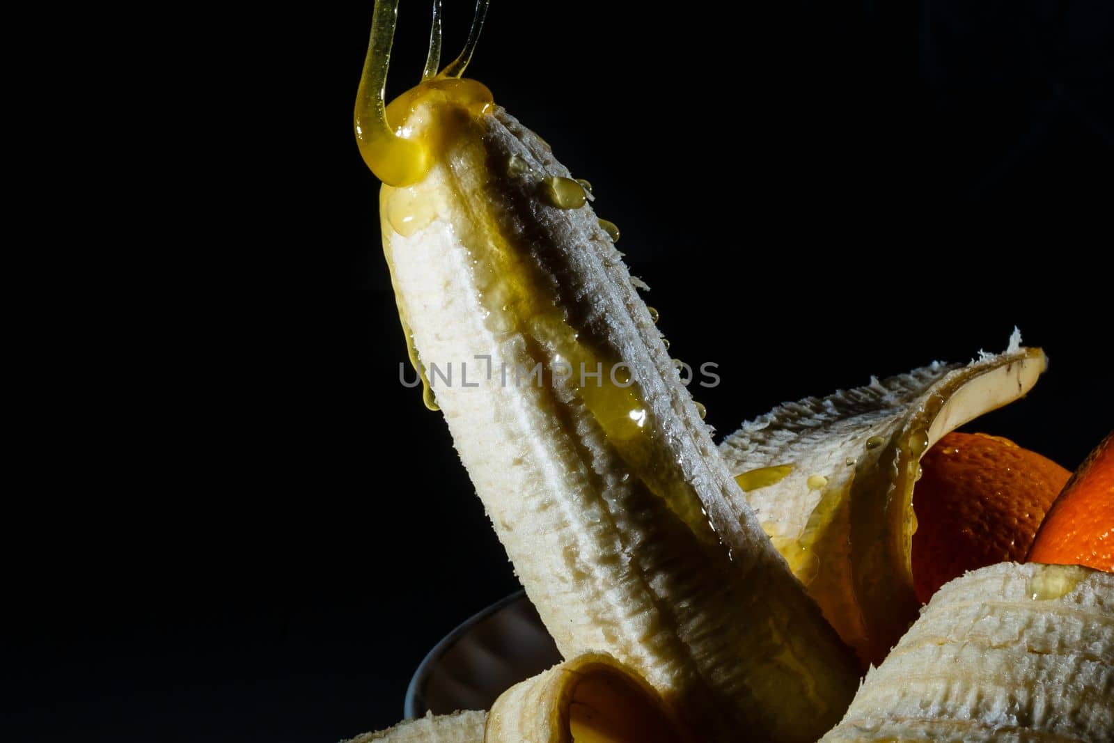 Banana covered with chocolate sauce and whipped cream on color background. Sex concept by Andelov13