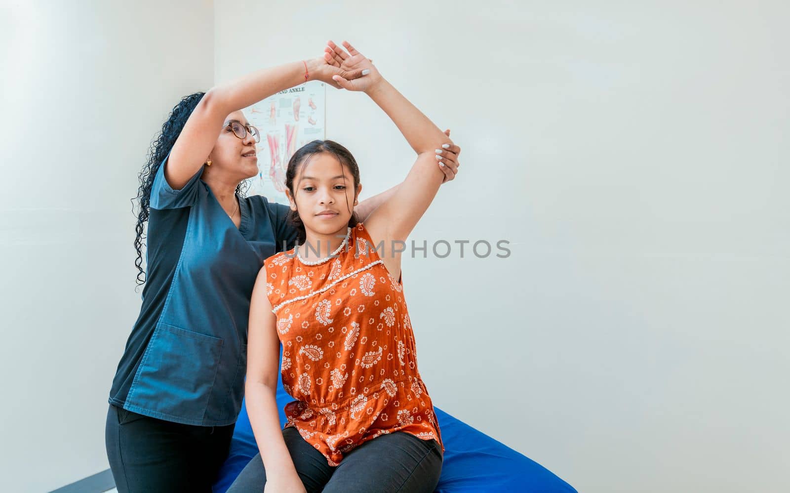 Young physiotherapist with patient rehabilitating shoulder and elbow, Physiotherapist with female patient rehabilitating elbow. elbow and shoulder rehabilitation physiotherapy by isaiphoto