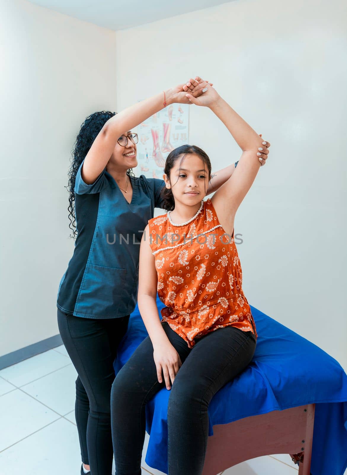Physiotherapist with female patient rehabilitating elbow. Young physiotherapist with patient rehabilitating shoulder and elbow, elbow and shoulder rehabilitation physiotherapy