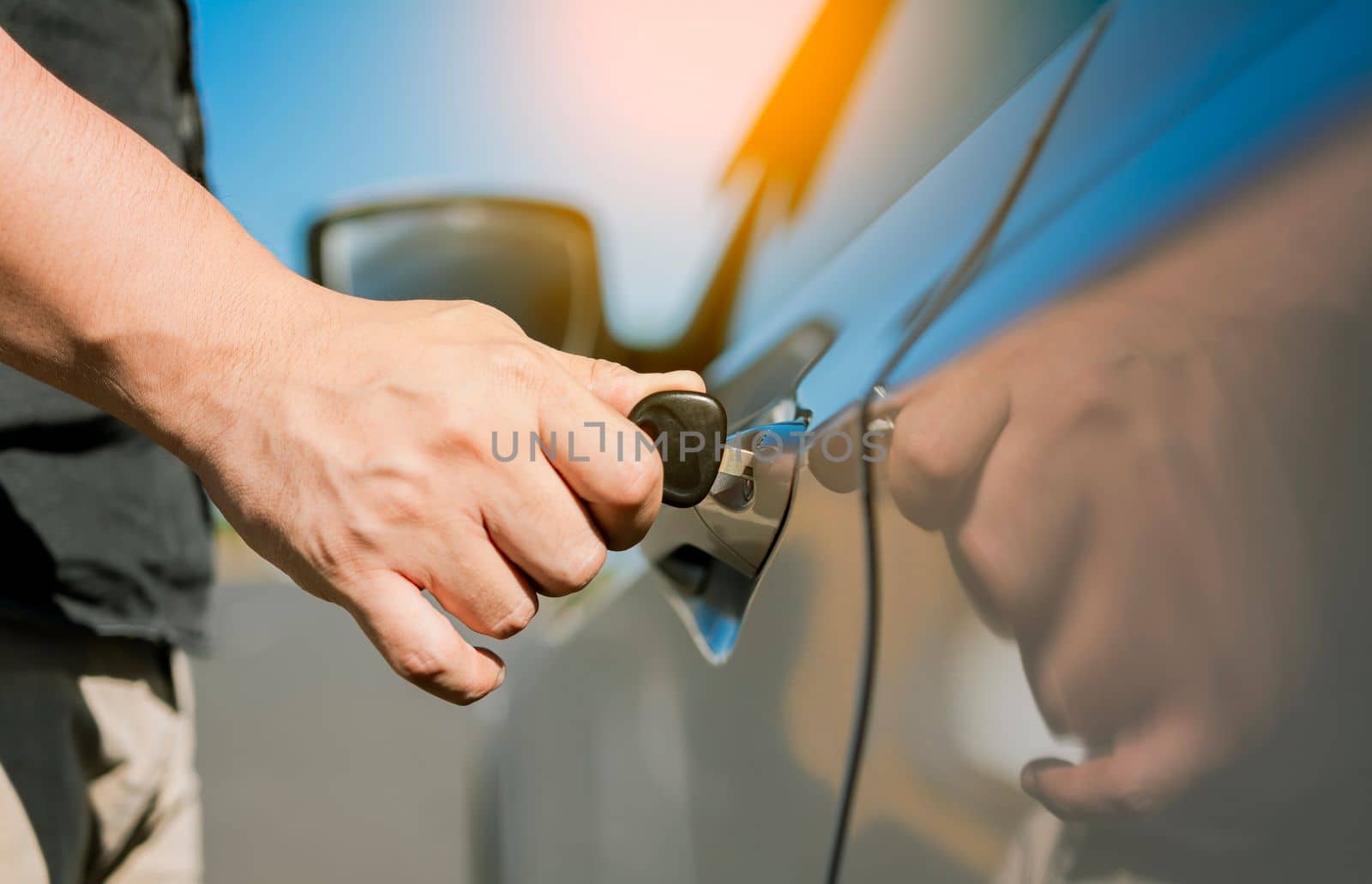 Hands with keys opening the car door. Close-up of hands opening the car door with the key. Vehicle owner opening the door with the keys. by isaiphoto