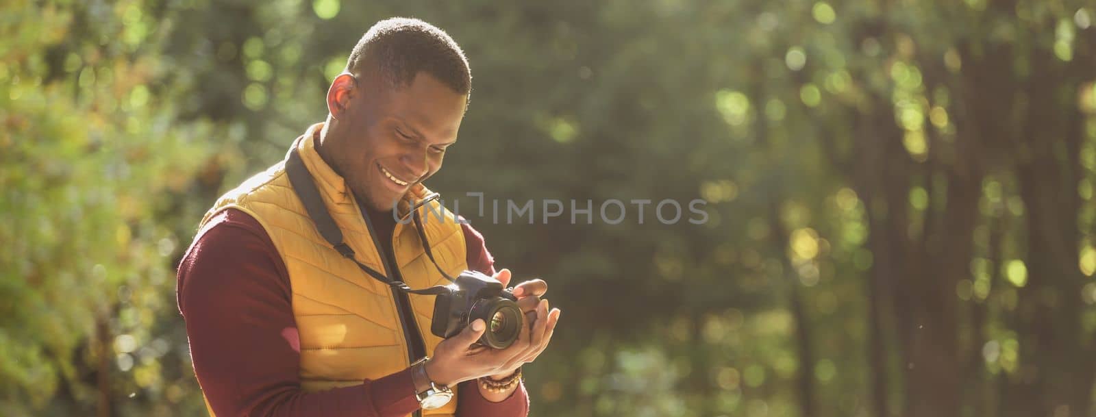 Banner african american guy photographer taking picture with photo camera on city green park copy space and place for text - leisure activity, diversity and hobby concept by Satura86