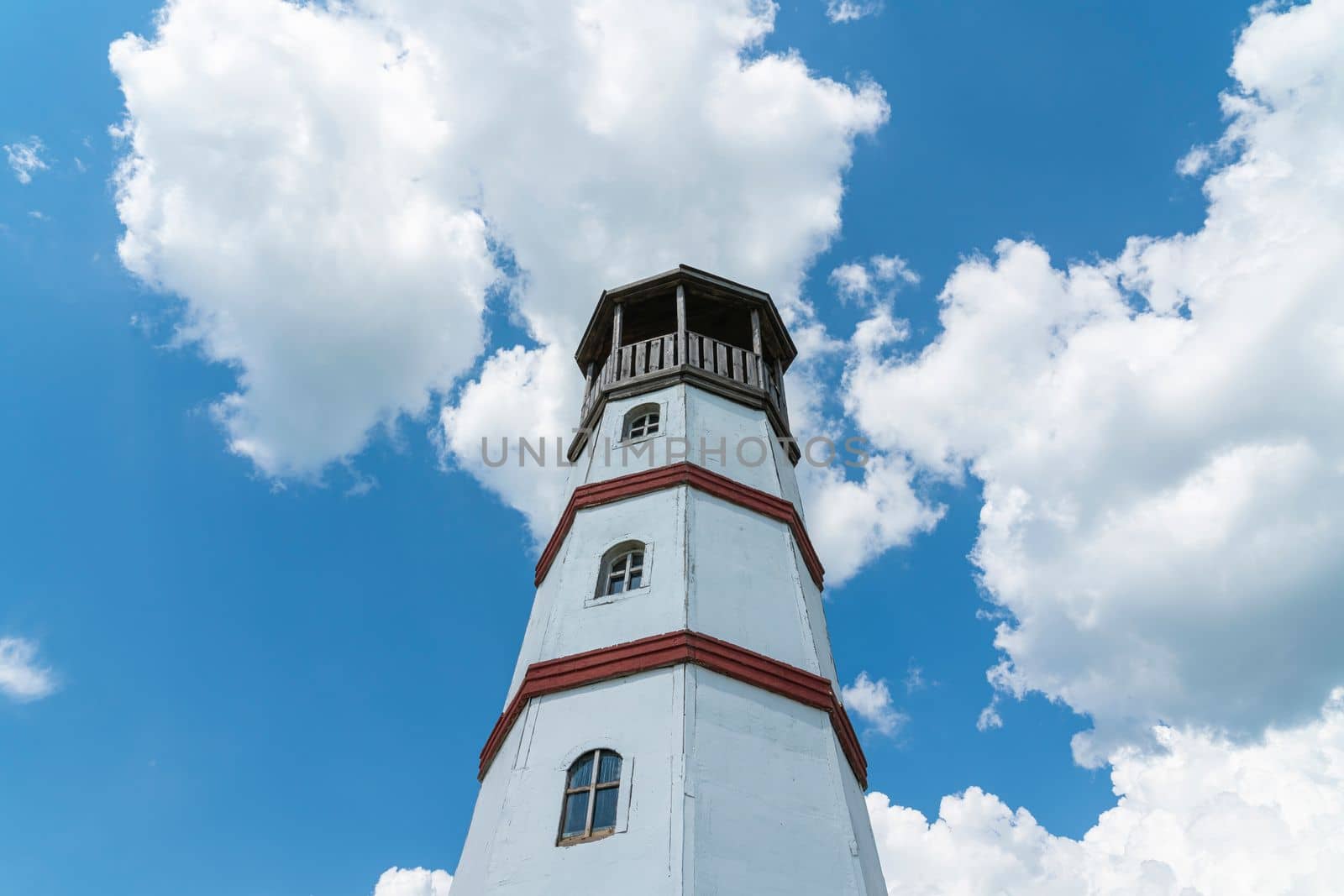 the old lighthouse against the blue sky by roman112007