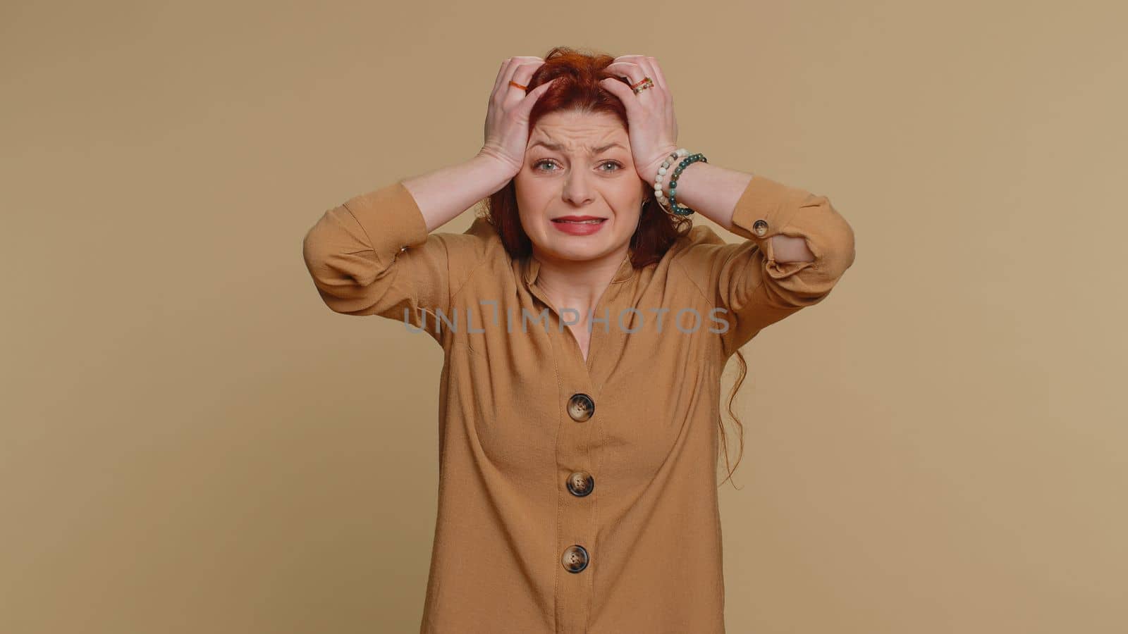 Young redhead woman feeling hopelessness loneliness, nervous breakdown, loses becoming surprised by lottery results, bad fortune, loss, unlucky news. Caucasian girl isolated on studio beige background