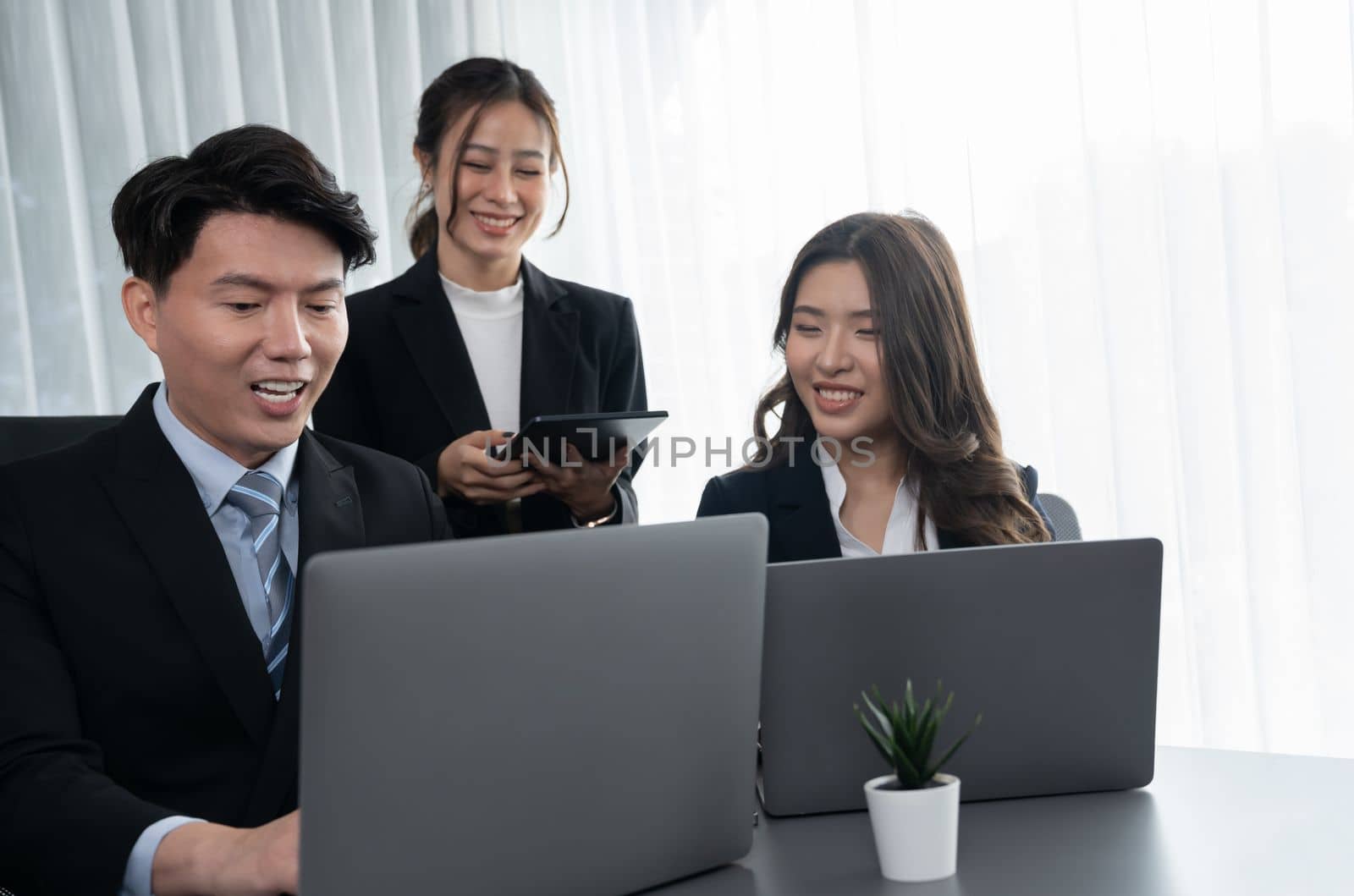 Harmony in office concept as business people analyzing dashboard paper together in workplace. Young colleagues give ideas at manager desk for discussion or strategy planning about project.