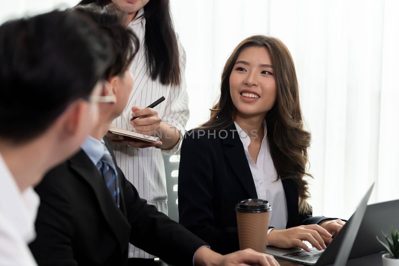 Focus portrait of female manger, businesswoman in the harmony meeting room with blurred of colleagues working together, analyzing financial paper report and dashboard data in background.