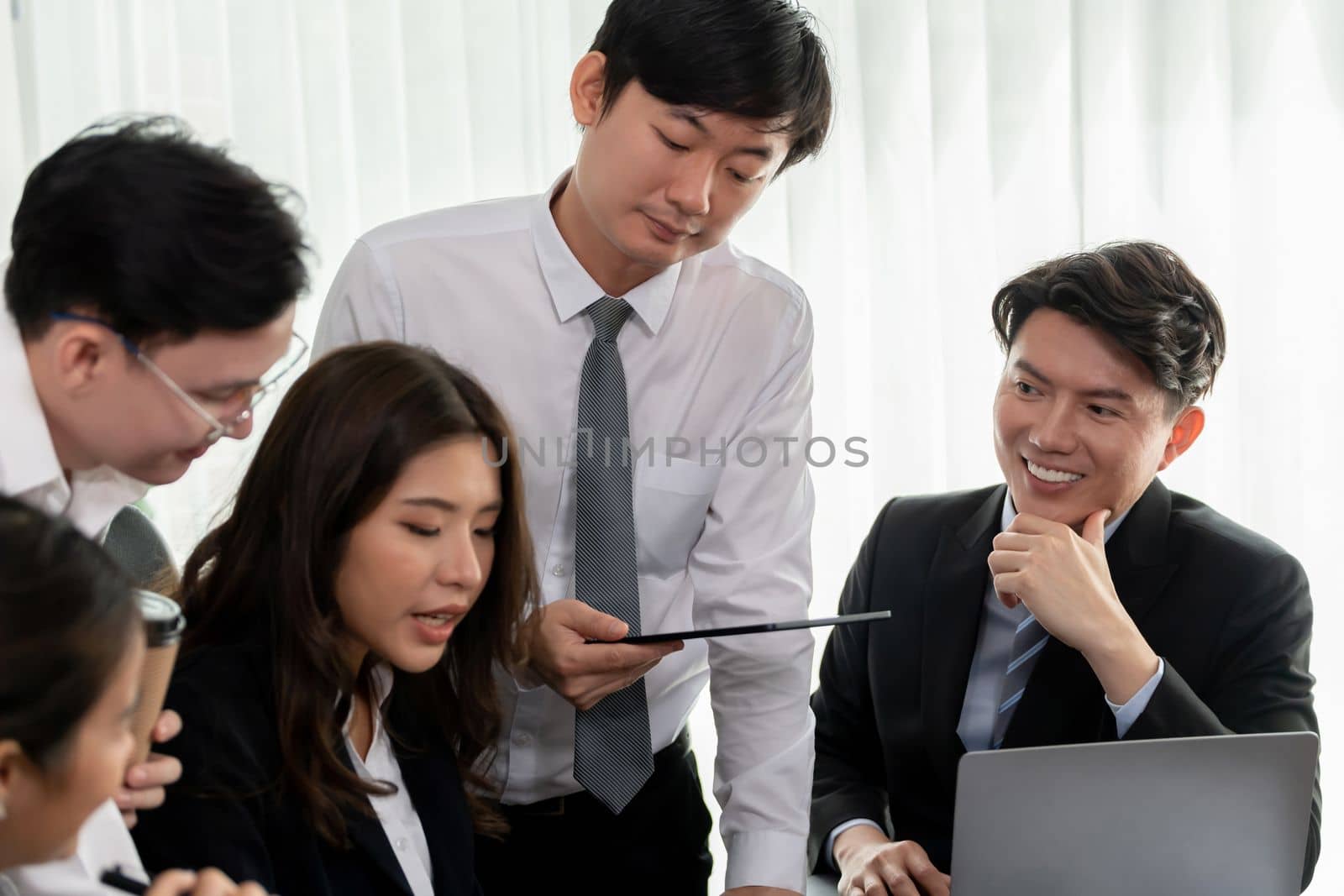 Harmony in office concept as business people analyzing dashboard paper together in workplace. Young colleagues give ideas at manager desk for discussion or strategy planning about project.