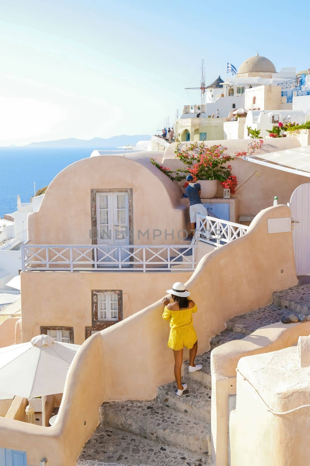 Asian women visit Oia Santorini Greece during summer with whitewashed homes and churches by fokkebok