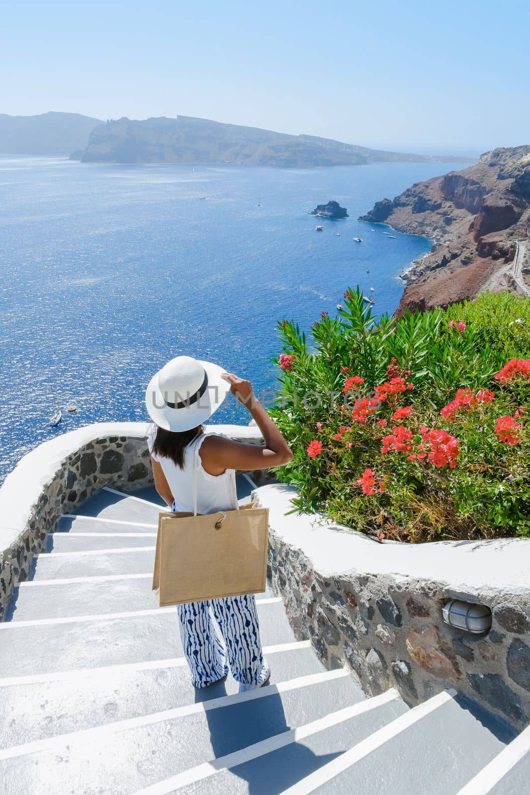 Asian woman visit Oia Santorini Greece during summer with whitewashed homes and churches by fokkebok
