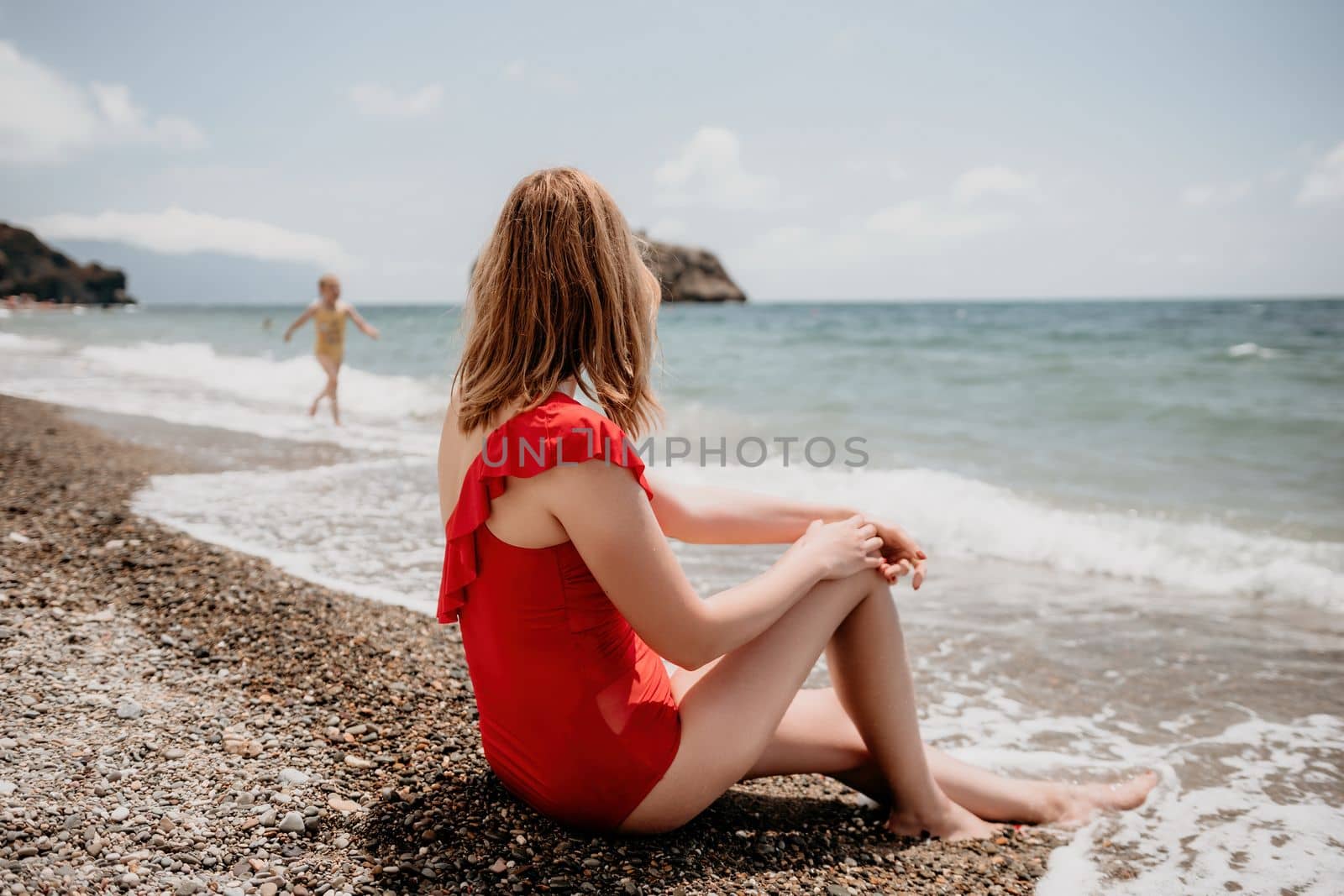 Happy loving family mother and daughter having fun together on the beach. Mum playing with her kid in holiday vacation next to the ocean - Family lifestyle and love concept.