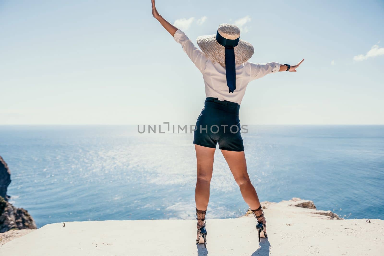 Woman sea hat. Business woman in yellow hat freelancer working over blue sea beach. Girl relieves stress from work. Freelance, digital nomad, travel and holidays concept by panophotograph