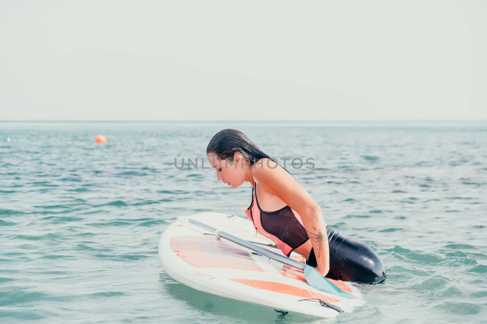 Sea woman sup. Silhouette of happy young woman in pink bikini, surfing on SUP board, confident paddling through water surface. Idyllic sunset. Active lifestyle at sea or river. Slow motion