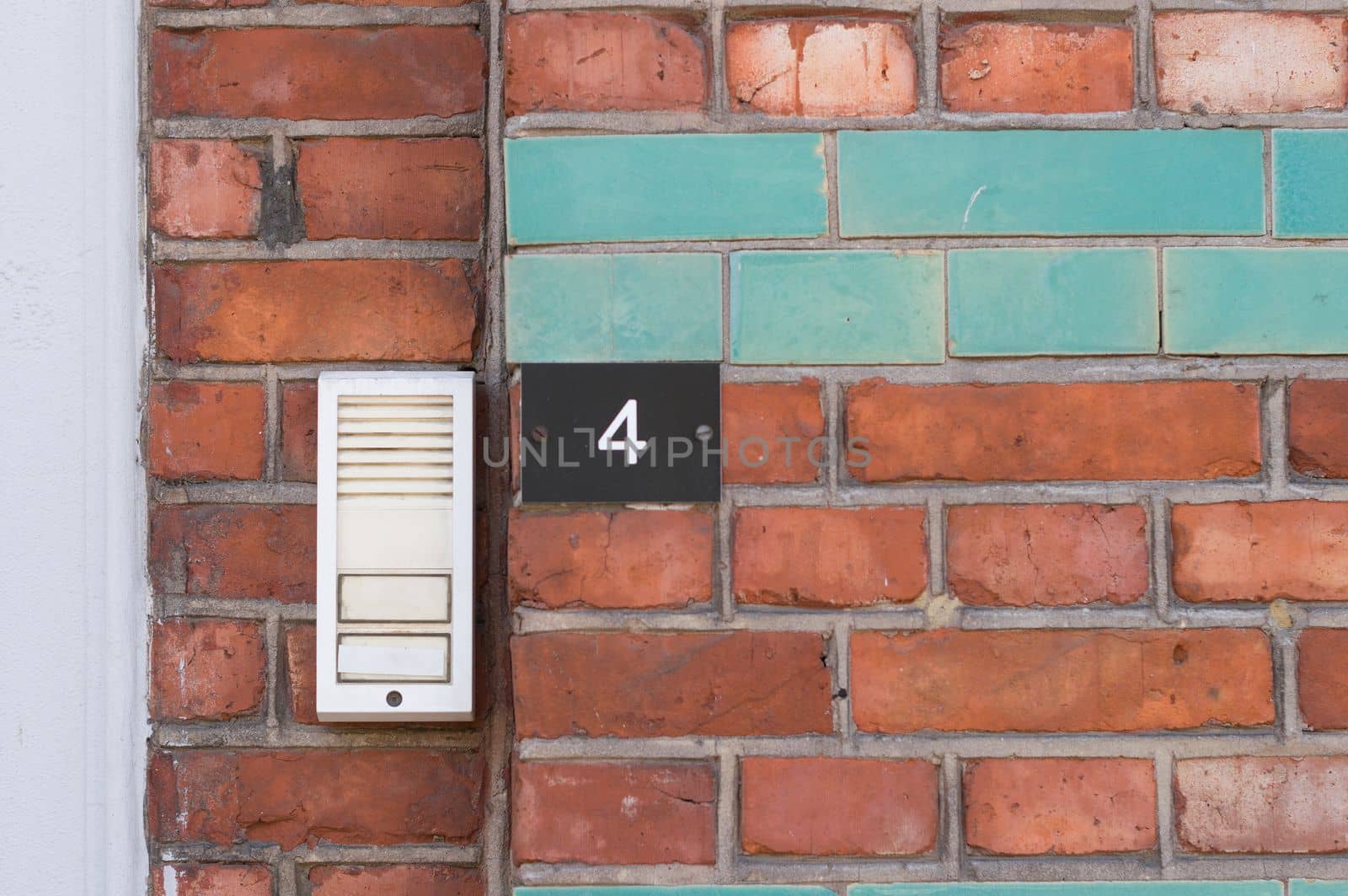 natural red brick background, masonry texture, house stone wall with blue color ceramic tiles insert, house doorbell number 4 on the wall, High quality photo