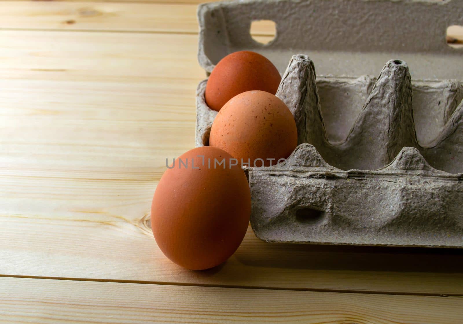 Eggs in a cardboard box close-up. Eggs in a cardboard box on a wooden table.