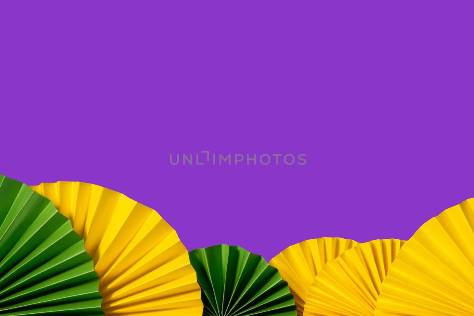 Mardi gras festive traditional color background. Abstract background yellow, green, purple. Paper fans Mardi gras celebration