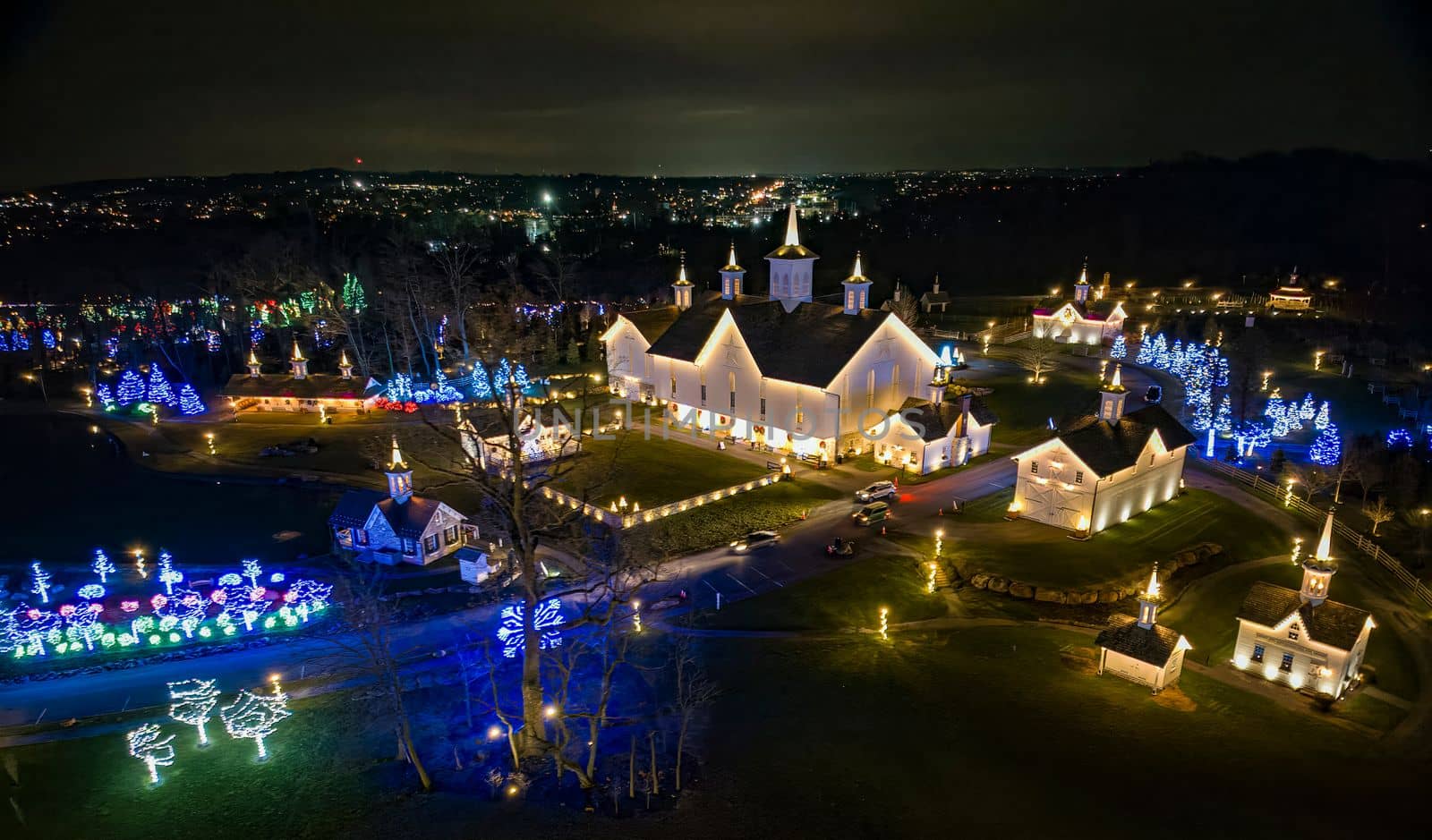 An Aerial View of a Large Christmas Drive Thru Display, with Multi Colored Lights, Seen at Night
