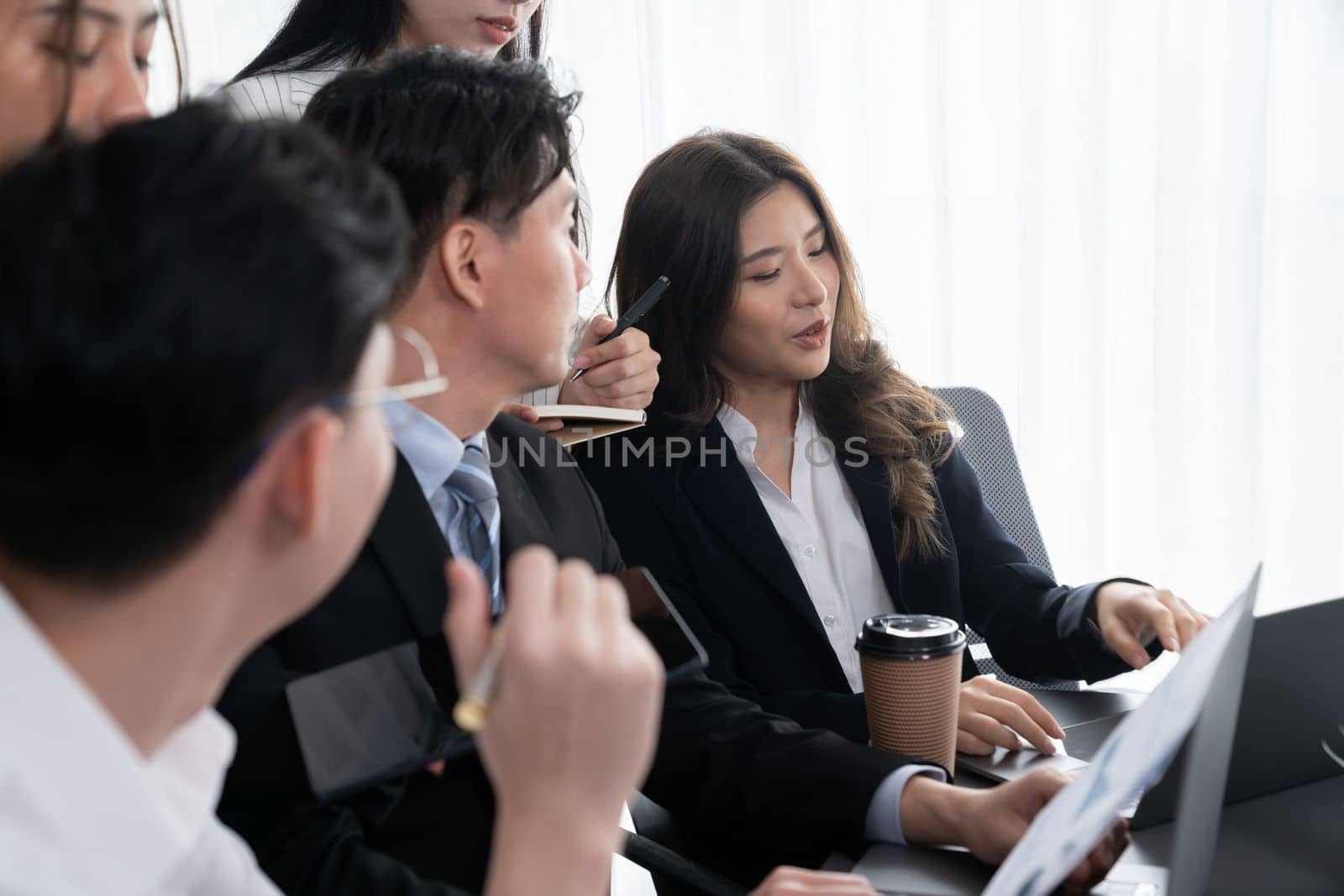 Harmony in office concept as business people analyzing dashboard paper together in workplace. Young colleagues give ideas at manager desk for discussion or strategy planning about project.