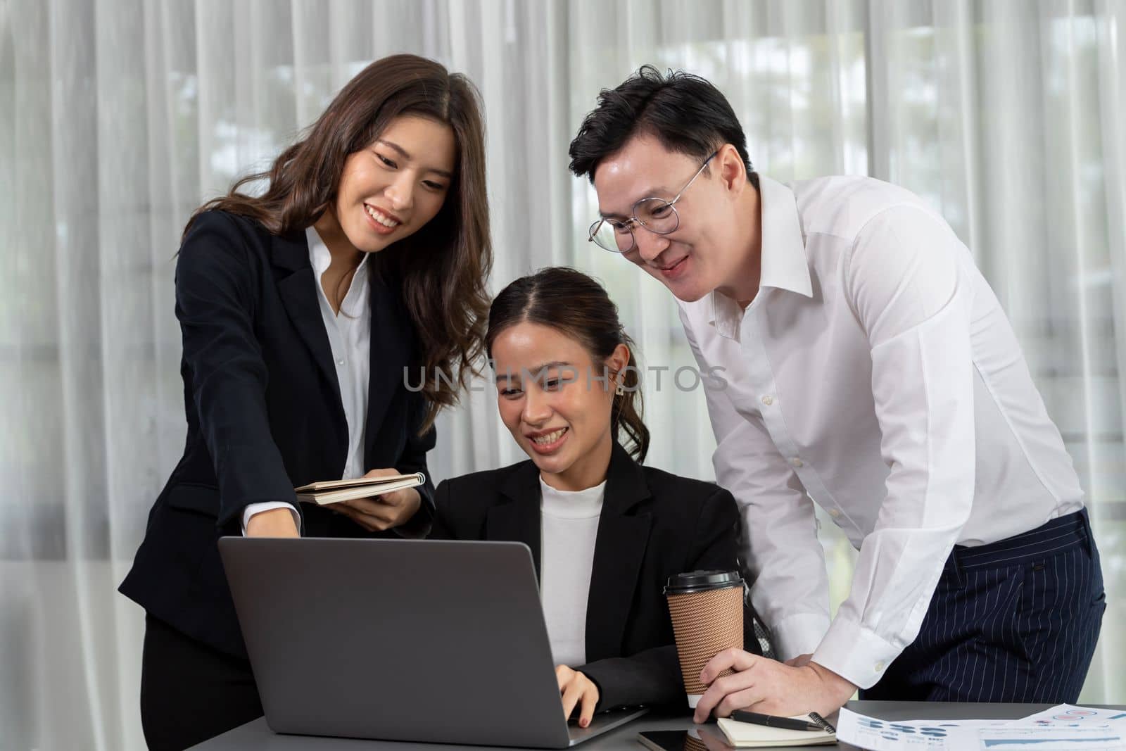 Harmony in office concept as business people analyzing dashboard paper together in workplace. Young colleagues give ideas at manager desk for discussion or strategy planning about project.