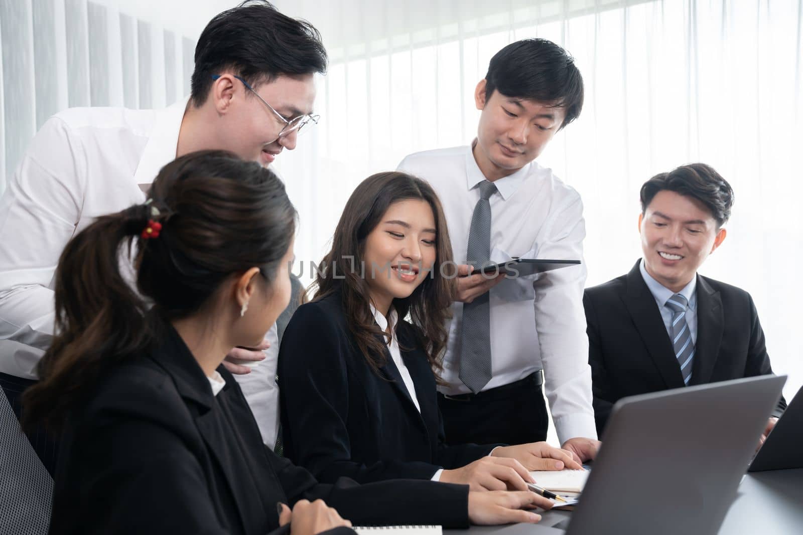 Harmony in office concept as business people analyzing dashboard paper together in workplace. Young colleagues give ideas at manager desk for discussion or strategy planning about project.