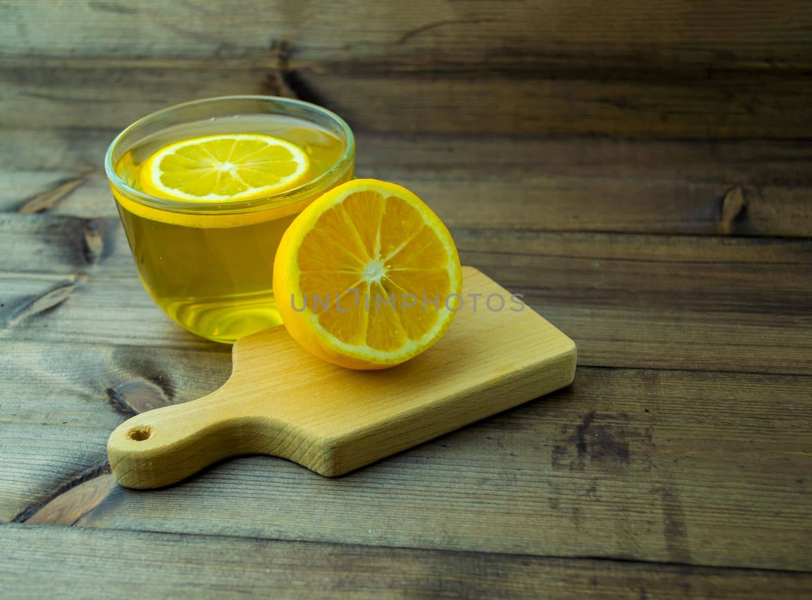 Green tea in a mug and lemon. Green tea in a mug and lemon on a wooden table.