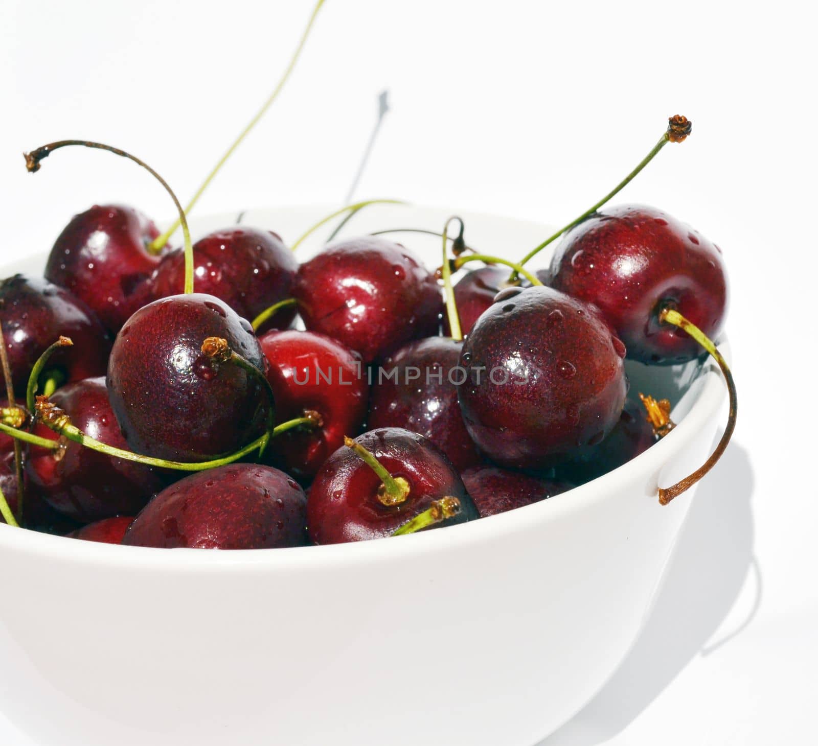 Cherry in a bowl on a white background.