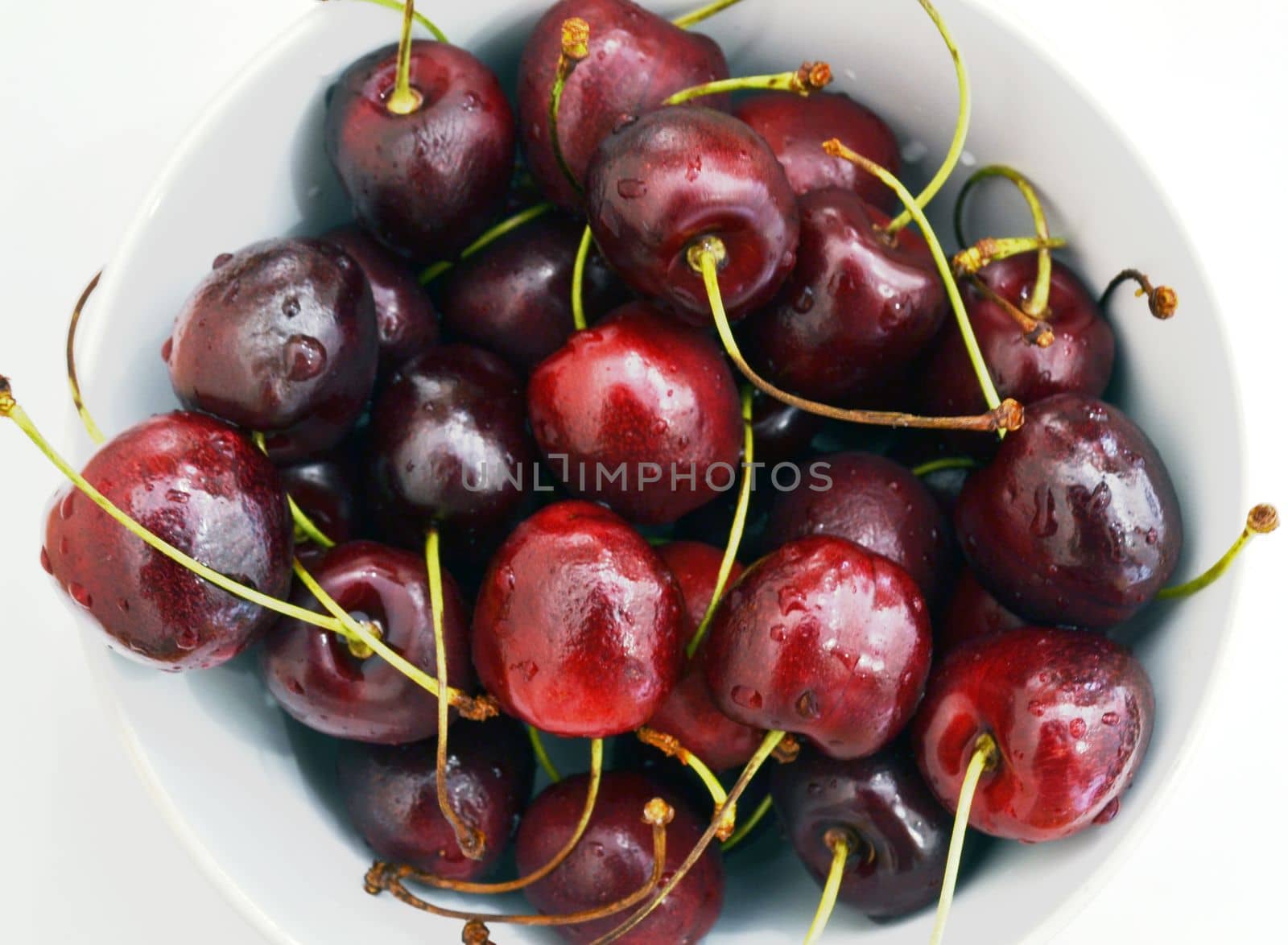 Cherry in a bowl on a white background.