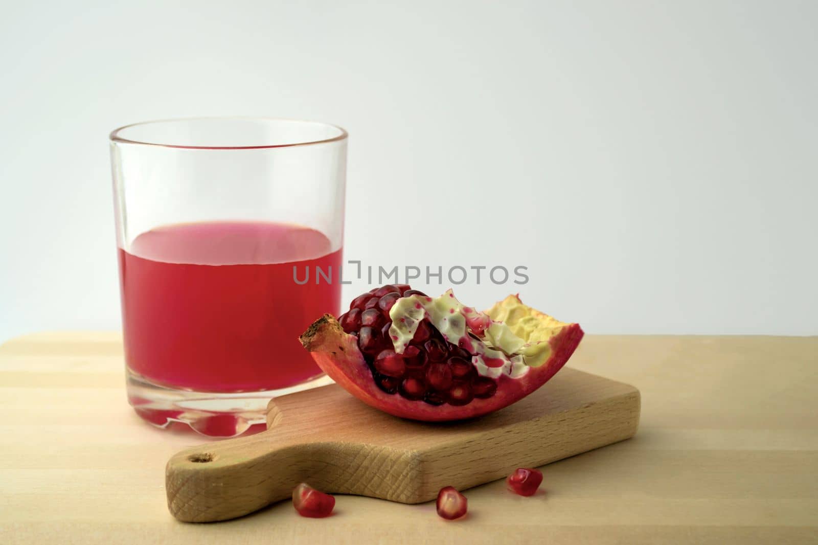 Pomegranate and pomegranate juice, photo. Photo of pomegranate and pomegranate juice in a glass on a wooden table.