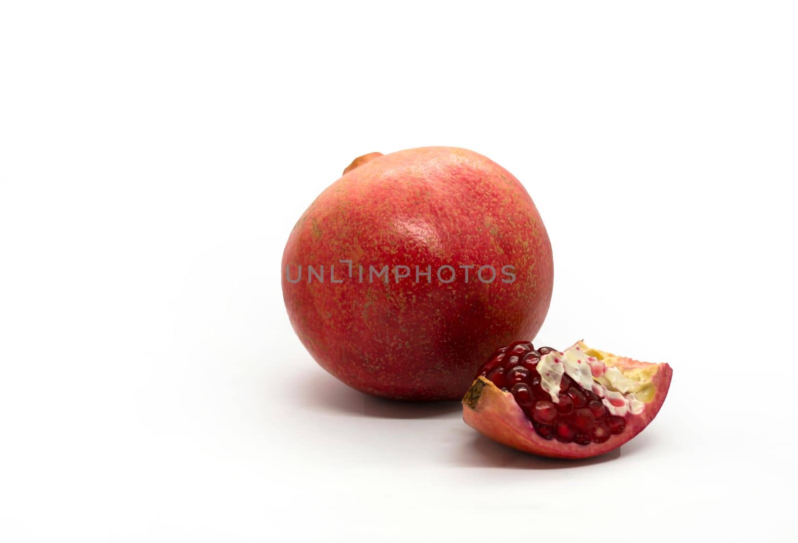 Pomegranate and pomegranate slice, photo. Pomegranate and pomegranate slice on a white background.