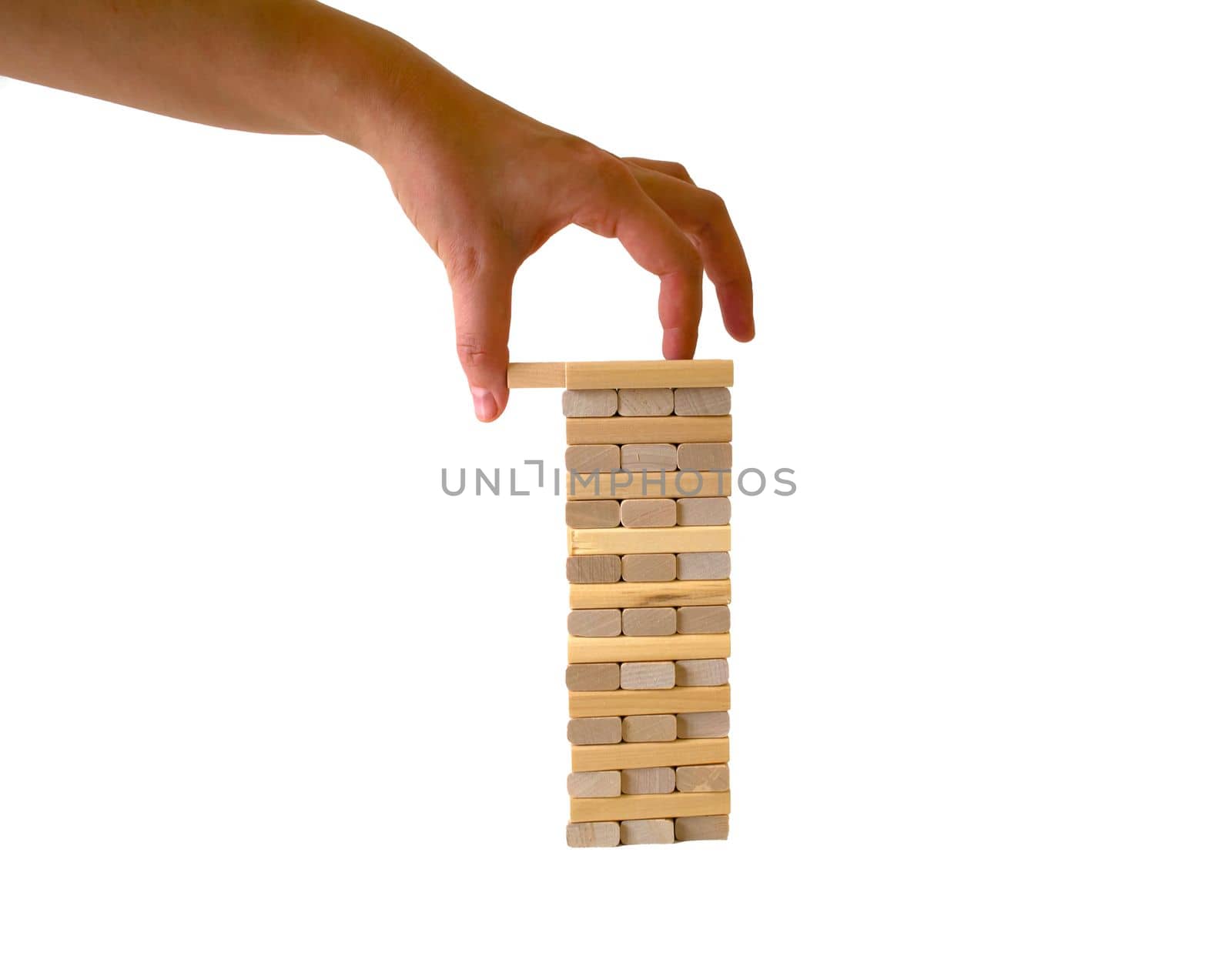 Jenga game. Photo of a plank tower, a game of jenga on a white background, a woman's hand pulls out a plank. Isolated.