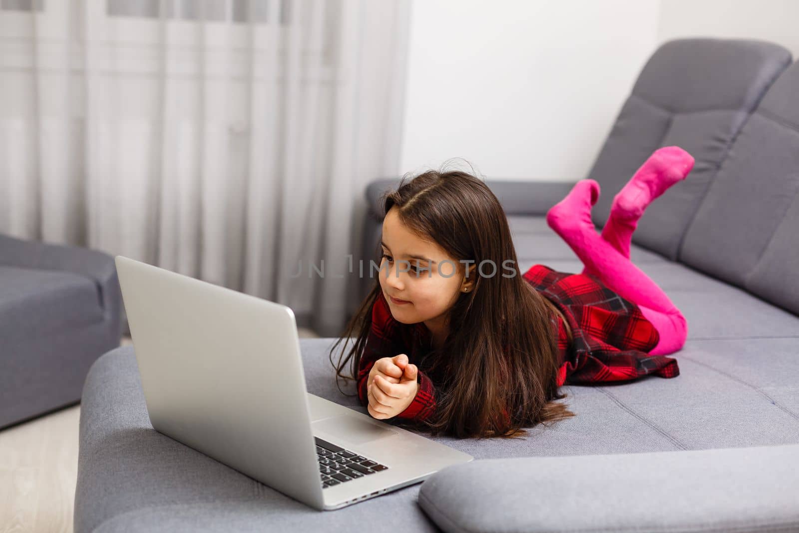 Little girl learning English indoors at online lesson by Andelov13