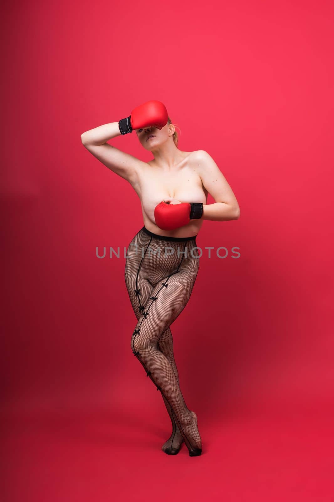 Seductive confident female boxer with gloves studio, sporty woman posing looking at camera. by Zelenin
