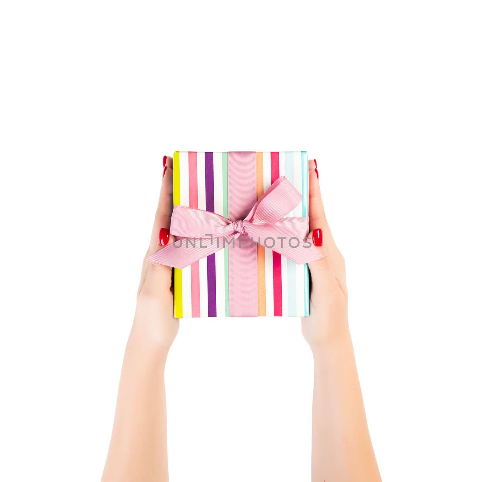 Woman hands give wrapped Christmas or other holiday handmade present in colored paper with pink ribbon. Isolated on white background, top view. thanksgiving Gift box concept.